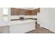 A well-designed kitchen with stainless steel appliances, stylish brown cabinetry, and a spacious center island with quartz countertop at 13392 E 110Th Way, Commerce City, CO 80022