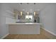 Modern kitchen with an island, stainless steel appliances, and open shelving at 3520 W Conejos Pl # 14, Denver, CO 80204