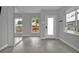 Spacious living room with light grey walls, a large mirror, and large windows overlooking the front yard at 3520 W Conejos Pl # 14, Denver, CO 80204