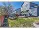 Backyard with a well-maintained lawn, a trampoline, and an outdoor dining set on a wooden deck at 9694 Canberra Dr, Highlands Ranch, CO 80130
