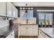 Stylish kitchen showcasing white cabinetry, black countertops, modern fixtures, and stainless steel appliances at 9694 Canberra Dr, Highlands Ranch, CO 80130