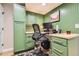 Well-lit home office with custom built-in cabinets, a spacious desk, and comfortable ergonomic chair at 9694 Canberra Dr, Highlands Ranch, CO 80130