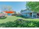 Beautiful backyard featuring lush lawn, a shed, mature trees, and a covered patio area for relaxation at 6621 S Cherry Way, Centennial, CO 80121
