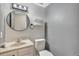 This bathroom features a round mirror, floating shelves and a toilet at 6621 S Cherry Way, Centennial, CO 80121