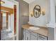 Bathroom with wood paneled walls, gray vanity, and a view of the shower at 6621 S Cherry Way, Centennial, CO 80121