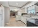 Bright kitchen featuring white cabinets, modern countertops, and an open view to the living area at 6621 S Cherry Way, Centennial, CO 80121