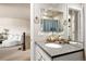 Well-lit bathroom featuring a vanity with a gray countertop and chrome fixtures, and a view into the living area at 14833 E Crestridge Dr, Centennial, CO 80015