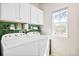 Functional laundry room with washer, dryer, storage cabinets, and a window for natural light at 14833 E Crestridge Dr, Centennial, CO 80015