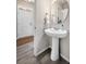 Stylish powder room with a pedestal sink, modern faucet, and hardwood floors at 14833 E Crestridge Dr, Centennial, CO 80015