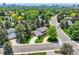 Stunning aerial view of a home with lush landscaping, circular driveway and mature trees in a desirable neighborhood at 10130 E Powers Ave, Greenwood Village, CO 80111