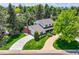 Aerial view of a home with a well-manicured lawn, mature trees, and a winding driveway at 10130 E Powers Ave, Greenwood Village, CO 80111