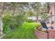 Lush backyard with manicured lawn, mature trees, and a brick-lined patio area at 10130 E Powers Ave, Greenwood Village, CO 80111