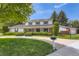 Charming two-story home with lush landscaping, circular driveway, and well-maintained lawn at 10130 E Powers Ave, Greenwood Village, CO 80111