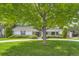 Charming single-story home with well-manicured lawn, mature trees, and a welcoming facade at 10130 E Powers Ave, Greenwood Village, CO 80111