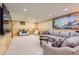 Spacious living room with a large sectional sofa and a wall-mounted TV, perfect for entertainment at 10130 E Powers Ave, Greenwood Village, CO 80111