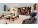 Cozy living room featuring a large bookcase, classic furnishings, and neutral carpet at 10130 E Powers Ave, Greenwood Village, CO 80111