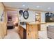 Open-concept living room with a bar area, seamless access to a bedroom, and entertainment options at 10130 E Powers Ave, Greenwood Village, CO 80111
