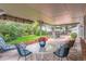 Inviting covered patio with a seating area overlooking a well-maintained backyard with beautiful landscaping at 10130 E Powers Ave, Greenwood Village, CO 80111