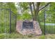 Sundance Park entrance sign with stone base, set behind a black wrought iron fence at 10130 E Powers Ave, Greenwood Village, CO 80111