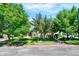 Charming townhome with mature landscaping, a well-maintained lawn and a red front door at 13271 Holly St # B, Thornton, CO 80241