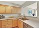 Kitchen area with stylish countertops, sink, and natural wood cabinetry at 13271 Holly St # B, Thornton, CO 80241