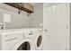 Convenient laundry room includes a modern washer, dryer, and helpful above storage shelving at 13271 Holly St # B, Thornton, CO 80241