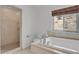 Bathroom features a soaking tub, walk-in shower, and scenic window at 5265 Club Ct, Larkspur, CO 80118
