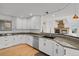 Clean kitchen featuring white cabinets, granite countertops, stainless steel appliances, and hardwood floors at 5265 Club Ct, Larkspur, CO 80118
