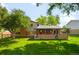 Expansive backyard showcasing a green lawn, mature trees, and a charming brick-accented covered patio at 9325 Meade St, Westminster, CO 80031