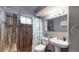 Basement bathroom with a walk-in shower, pedestal sink, and updated tile at 1242 Elder St, Denver, CO 80221