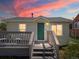 Charming home featuring a cozy front deck, green door, and serene sunset hues at 3134 W Center Ave, Denver, CO 80219