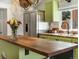 Bright kitchen featuring butcher block counters, stainless steel appliances, and modern green cabinets at 3134 W Center Ave, Denver, CO 80219