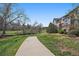 Townhome exterior featuring a walking path, grassy lawn, creek, and landscaping at 6004 W Colorado Ln, Lakewood, CO 80232