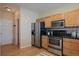 Updated kitchen features stainless steel appliances, wood cabinets, and wood flooring at 6004 W Colorado Ln, Lakewood, CO 80232