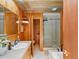 Beautiful bathroom with dual sinks, wood paneling, and a glass-enclosed shower for a spa-like experience at 10400 W 35Th Pl, Wheat Ridge, CO 80033
