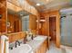 Elegant bathroom featuring dual sinks, wood paneling, and a separate shower area for added convenience at 10400 W 35Th Pl, Wheat Ridge, CO 80033