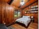 Cozy bedroom with wood paneled walls and ceilings, large windows, and a bookshelf at 10400 W 35Th Pl, Wheat Ridge, CO 80033