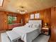 Bedroom featuring wood paneled walls, large windows, modern lighting, and a comfortable bed at 10400 W 35Th Pl, Wheat Ridge, CO 80033