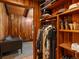 Custom closet featuring wood paneling, hanging clothes, and shelving with hats, shoes, and decorative items at 10400 W 35Th Pl, Wheat Ridge, CO 80033