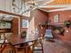 Sunlit dining area featuring a brick fireplace, stone floors, and a cozy seating area perfect for relaxation at 10400 W 35Th Pl, Wheat Ridge, CO 80033