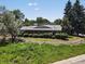 Brick home surrounded by mature trees, bushes and flower garden at 10400 W 35Th Pl, Wheat Ridge, CO 80033