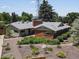 Angle shot of a home featuring brick and sage green paint, surrounded by colorful landscaping at 10400 W 35Th Pl, Wheat Ridge, CO 80033