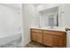 Bright bathroom featuring double sinks, wood cabinets and a shower over tub at 2079 Generations Aly, Brighton, CO 80601