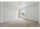 Empty bedroom featuring neutral carpet, a window, and a door at 2079 Generations Aly, Brighton, CO 80601