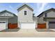 Exterior view of a two-story home with a white garage door and gray siding at 2079 Generations Aly, Brighton, CO 80601