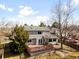 Backyard view of a two-story home with a deck, mature trees, and lawn at 3819 S Waco St, Aurora, CO 80013