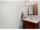 Powder room with wood vanity, white sink and mirror at 3819 S Waco St, Aurora, CO 80013