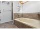Bathroom featuring a large tub with tile surround and a window at 3819 S Waco St, Aurora, CO 80013