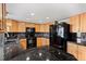 Bright kitchen features granite countertops, black appliances, and wood cabinets at 3819 S Waco St, Aurora, CO 80013