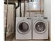 Laundry room features a newer washer and dryer with an exposed brick foundation at 3819 S Waco St, Aurora, CO 80013